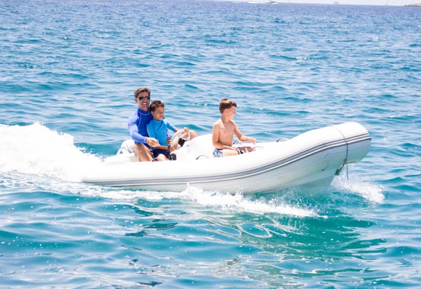 Man met twee kinderen op een rubberboot met kabelbesturing